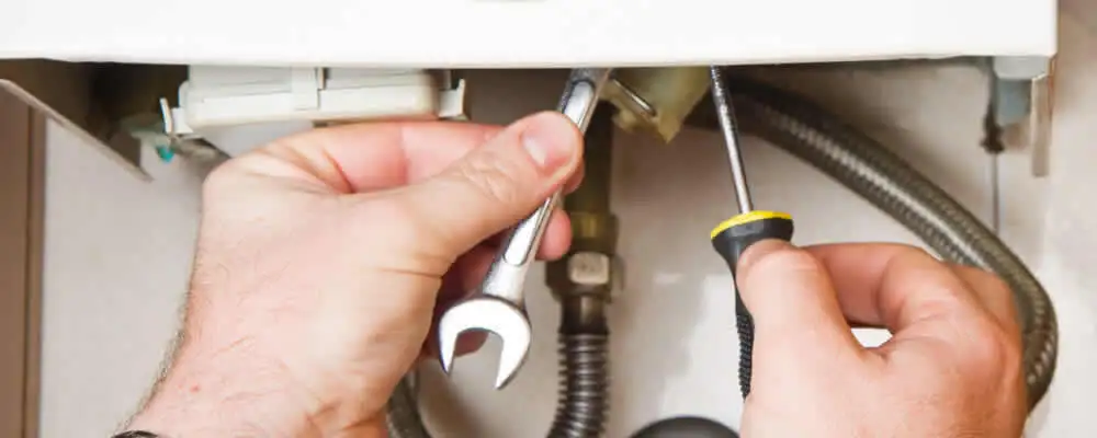 Boiler repair technician tightening pipe fittings and connections in Buffalo, NY