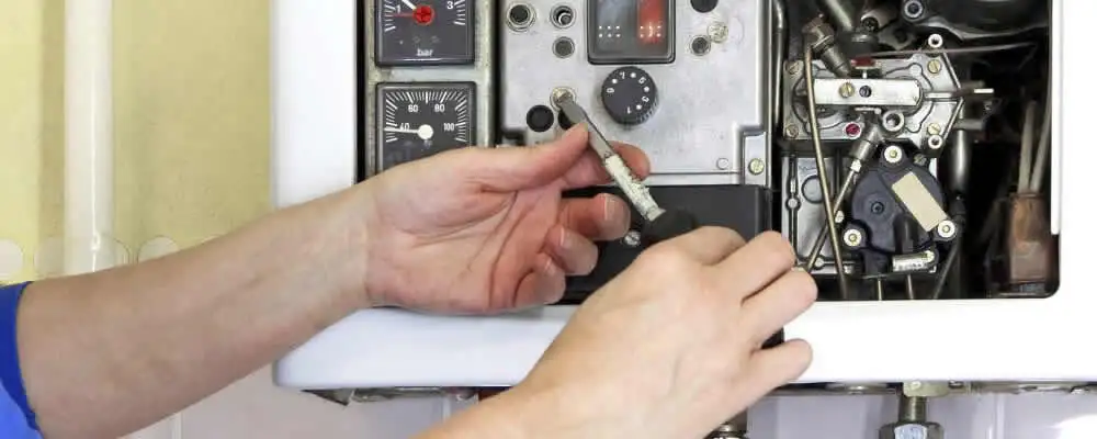 Heating repair technician adjusting boiler controls and components in Buffalo, NY