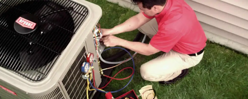 HVAC technician servicing an outdoor air conditioner unit in Buffalo, NY