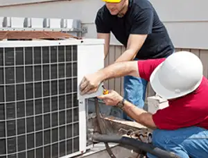 HVAC technicians repairing an outdoor AC unit on a rooftop in Buffalo, NY