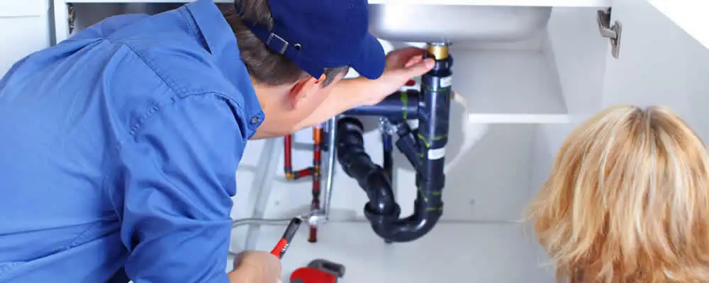 Plumber repairing under-sink drain pipes and fittings in Buffalo, NY